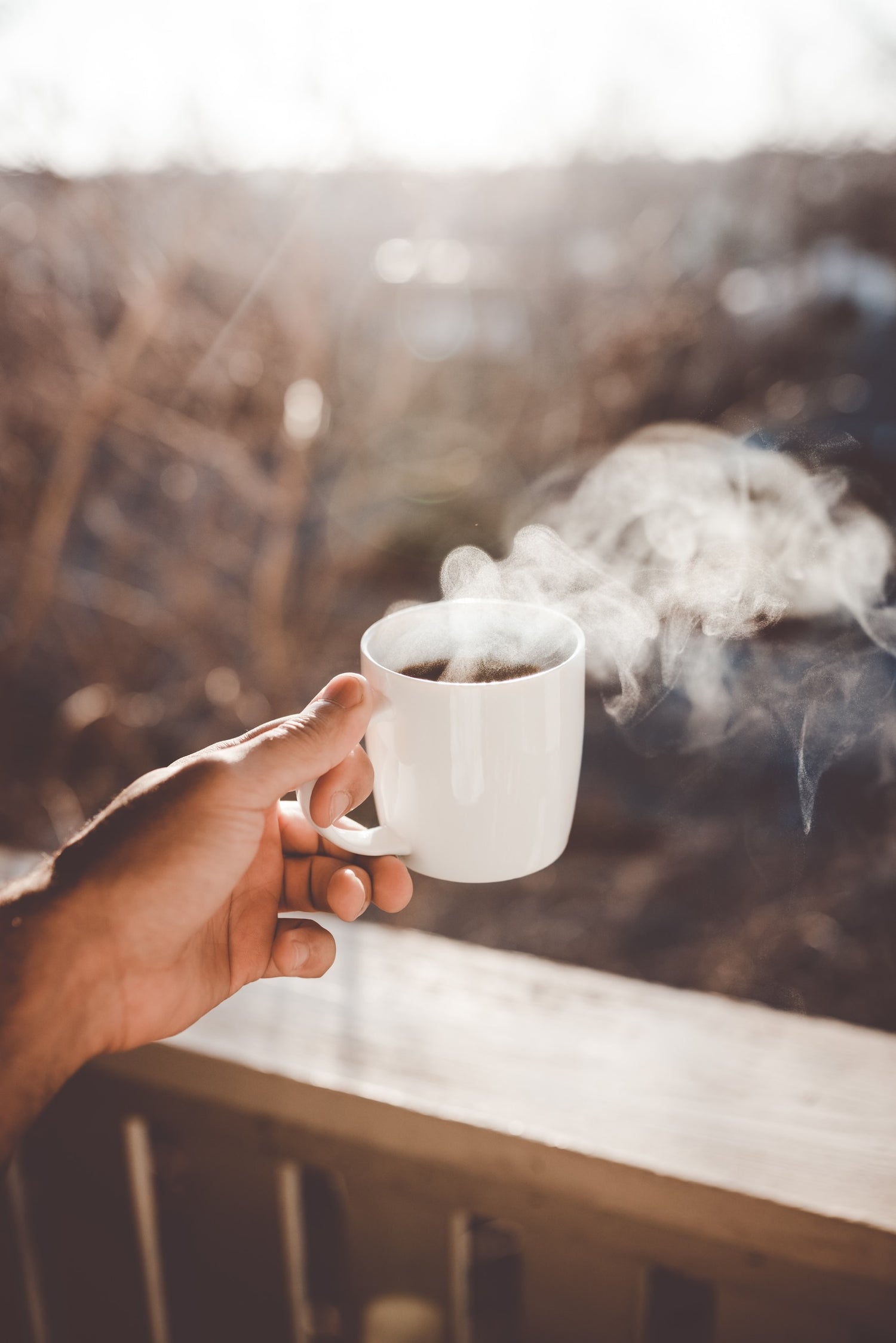 Coffee roaster Nova Scotia-man holding hot cup of coffee on his patio