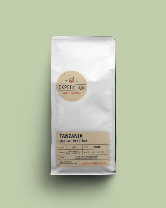 Coffee bag of Tanzania Songwe Peaberry beans labeled 'Expedition Coffee Roasters' on a light green background